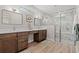 Modern bathroom featuring double vanities, marble shower with glass enclosure, and wood-look floors at 1001 Brantley L Brantley Ln., North Myrtle Beach, SC 29582