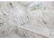 Bright bathroom showcasing a luxurious soaking tub with marble surround and a window at 1001 Brantley L Brantley Ln., North Myrtle Beach, SC 29582
