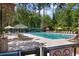 Large community pool with lounge chairs and umbrellas surrounded by tall trees at 1001 Brantley L Brantley Ln., North Myrtle Beach, SC 29582