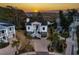 Aerial view of a beautiful white house with palm trees and a sunset with city view on the horizon at 1004 Marsh View Dr., North Myrtle Beach, SC 29582