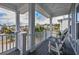 Relaxing covered porch with cozy seating, offering views of the surrounding neighborhood and lush greenery at 1004 Marsh View Dr., North Myrtle Beach, SC 29582