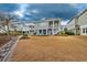 Stunning home with a spacious backyard, patio area, and stairs leading to a deck at 1004 Marsh View Dr., North Myrtle Beach, SC 29582