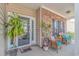 Inviting front porch with wicker seating, decorative plants, and charming brick accents creating a cozy entrance at 110 Echaw Dr., Conway, SC 29526