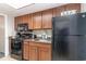 Kitchen area with a black refrigerator, microwave, and stove top near a sink and cabinets at 1105 S Ocean Blvd. # 220, Myrtle Beach, SC 29577