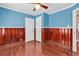 Bedroom features blue walls with wooden paneling, hardwood floors, and two white doors at 111 S Poplar Dr., Surfside Beach, SC 29575