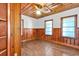 Bedroom featuring paneled walls, wooden floors, natural lighting, and a ceiling fan at 111 S Poplar Dr., Surfside Beach, SC 29575