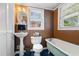 Charming bathroom with pedestal sink, clawfoot tub, and window offering natural light at 112 S Rosemary Ave., Andrews, SC 29510