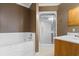 Bathroom featuring a tub, glass enclosed shower, and wooden vanity at 112 S Rosemary Ave., Andrews, SC 29510