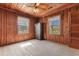 Bedroom featuring wood paneled walls and ceiling, carpeted floor and two windows with views at 112 S Rosemary Ave., Andrews, SC 29510