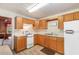 Bright kitchen featuring wood cabinets, white appliances, and wood-look vinyl flooring at 112 S Rosemary Ave., Andrews, SC 29510