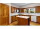 Well-lit kitchen featuring wood cabinets, white countertops, and an island at 112 S Rosemary Ave., Andrews, SC 29510