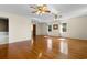 Bright living room featuring hardwood floors, two ceiling fans, and large windows at 112 S Rosemary Ave., Andrews, SC 29510