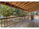 Inviting covered porch overlooking the landscaped yard with mature trees and white picket fence at 112 S Rosemary Ave., Andrews, SC 29510