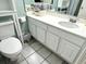 Inviting bathroom with tile floors and white cabinets featuring a sink and a toilet with storage at 1207 S Ocean Blvd. # 51104, Myrtle Beach, SC 29577