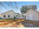 Home exterior featuring a backyard with mature trees, a small building, and ample space at 125 Dayglow Dr., Loris, SC 29569