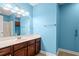 Bright bathroom with blue walls, a sink with dark wood cabinets, and vanity lighting at 125 Dayglow Dr., Loris, SC 29569