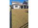 Large grassy backyard featuring black metal fencing and a gray home with a screened-in porch at 1330 Reflection Pond Dr., Little River, SC 29566