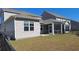 Backyard featuring a gray vinyl home and screened-in porch with a grassy lawn at 1330 Reflection Pond Dr., Little River, SC 29566