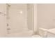 Bright bathroom featuring a shower-tub combo with white tiling and fixtures, and a standard white toilet at 1330 Reflection Pond Dr., Little River, SC 29566