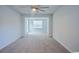 A bedroom with neutral walls and carpet, a ceiling fan, and a door leading to the backyard at 1330 Reflection Pond Dr., Little River, SC 29566