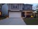 Two-story home with stone accents, a two-car garage, professional landscaping, and a cozy, covered front porch at 1330 Reflection Pond Dr., Little River, SC 29566