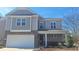 Inviting two-story home with stone accents, a covered front porch, and a lush lawn at 1330 Reflection Pond Dr., Little River, SC 29566