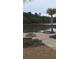 A stone fire pit and palm trees create a lakeside retreat for outdoor enjoyment and relaxation at 1330 Reflection Pond Dr., Little River, SC 29566
