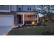Charming home exterior with manicured lawn, tasteful landscaping, and welcoming front porch illuminated by landscape lighting at 1330 Reflection Pond Dr., Little River, SC 29566