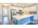 Modern kitchen featuring white cabinets, stainless steel appliances, a center island, and hardwood floors at 1330 Reflection Pond Dr., Little River, SC 29566