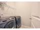 Functional laundry room with modern washer and dryer units, a wire shelf, and a closed door at 1330 Reflection Pond Dr., Little River, SC 29566