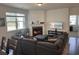 Open-concept living room with fireplace, hardwood floors, and natural light from large windows at 1330 Reflection Pond Dr., Little River, SC 29566