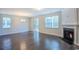 Spacious living room with hardwood floors, fireplace, two windows, and a glass sliding door at 1330 Reflection Pond Dr., Little River, SC 29566