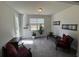 Bright, carpeted sitting room features two chairs, plants, neutral walls, and a door to the backyard at 1330 Reflection Pond Dr., Little River, SC 29566