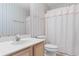 Well-lit bathroom with decorative striped wallpaper, a single sink vanity, and a shower with a white curtain at 1440 Blue Tree Ct. # N, Myrtle Beach, SC 29588