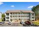 Three-story condo building with white siding, wooden railings, and parking in front at 1440 Blue Tree Ct. # N, Myrtle Beach, SC 29588