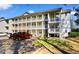 Condo building with white siding and wooden railings on balconies, showing parking area at 1440 Blue Tree Ct. # N, Myrtle Beach, SC 29588