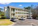 Exterior view of a condo building with multiple levels, balconies, and parking spaces with several cars at 1440 Blue Tree Ct. # N, Myrtle Beach, SC 29588