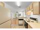 Well-lit kitchen with wooden cabinets, laminate flooring and standard appliances with views to the living room at 1440 Blue Tree Ct. # N, Myrtle Beach, SC 29588