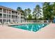 A fenced community pool with lounge chairs is ready for residents to enjoy on a sunny day at 1440 Blue Tree Ct. # N, Myrtle Beach, SC 29588