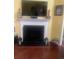 Cozy fireplace with white mantel and black metal screen and wood flooring at 1575 Berkshire Ave., Myrtle Beach, SC 29577