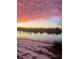 Picturesque lake view with vibrant sunset colors reflecting on the water and snow on the ground at 1575 Berkshire Ave., Myrtle Beach, SC 29577