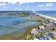 Stunning aerial view of coastal property with a pier, marsh, beach, and ocean views at 1582 S Waccamaw Dr. # 44, Murrells Inlet, SC 29576