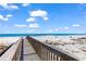 Scenic wooden walkway leads to a sandy beach and blue ocean, ideal for a relaxing vacation at 1582 S Waccamaw Dr. # 44, Murrells Inlet, SC 29576