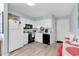 White kitchen features standard appliances, light wood flooring and breakfast area with red stools at 1582 S Waccamaw Dr. # 44, Murrells Inlet, SC 29576