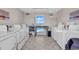 On-site laundry room with multiple washers and dryers, a folding table, and a window view of the pool at 1582 S Waccamaw Dr. # 44, Murrells Inlet, SC 29576