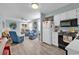 View of open concept living room and kitchen with light wood flooring, light blue walls and white appliances at 1582 S Waccamaw Dr. # 44, Murrells Inlet, SC 29576