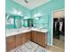Bright bathroom with dual sinks, a large mirror, a window, and a doorway leading to a walk-in closet at 1651 Fairforest Ct., Conway, SC 29526