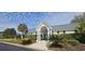 Exterior shot of community clubhouse with a welcoming entrance, well-manicured landscaping, and sunny skies at 182 Wimbledon Way # 182, Murrells Inlet, SC 29576