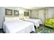Bright bedroom with two beds and a green armchair at 201 74Th Ave. N # 2549/2550, Myrtle Beach, SC 29577