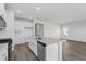 The open kitchen features a quartz island, modern stainless steel appliances, and white cabinets at 2020 Copper Creek Loop, Longs, SC 29568